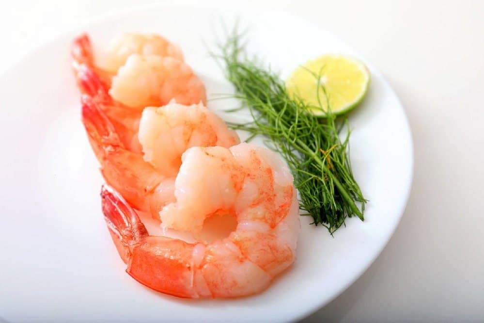 Blanched pink shrimp resting on ice, evenly cooked and kitchen-ready